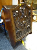 A heavily carved low country single-door hanging wall cabinet with lower shelf