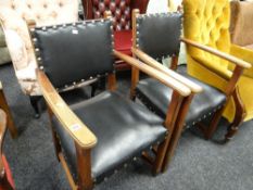 A pair of vintage black leatherette & studded armchairs