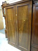 An antique mahogany two-door wardrobe with fitted interior