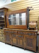An early twentieth century carved fronted three drawer three cupboard railback sideboard together