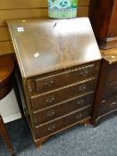 A reproduction mahogany drop front four-drawer compact bureau
