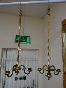 A pair of gilt metal hanging three-candle sconces