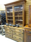 A good early twentieth century oak bookcase-chest with a bank of six drawers