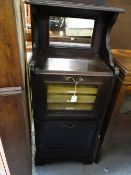 Early twentieth century mirror backed music cabinet with titled internal shelves