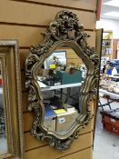 A small gilt plaster Rococo-style wall mirror