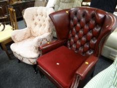 A vintage button backed silk print upholstered wingback chair together with a red leather button