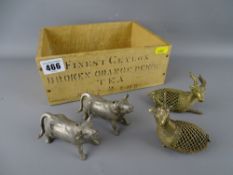 Four metal animal figurines in a vintage tea box