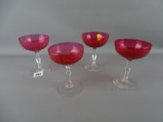 Four cranberry glass champagne glasses