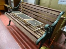 Wooden garden bench with metal ends and a small wrought iron glass topped display shelf