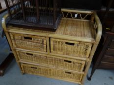 A wicker chest of drawers, two short above two long with a gallery top