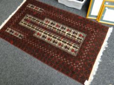 A dark ground Middle Eastern prayer rug with geometric design, 86 x 150cms