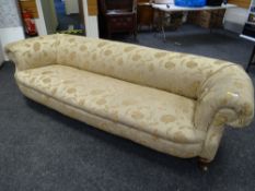 A Victorian upholstered roll-back sofa, 70 x 250 x 100cms