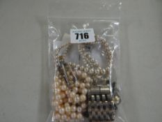 Two pearl necklaces with a white metal & stone set brooch & a white metal bracelet