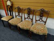 Three ornately carved walnut dining chairs together with a mahogany Art Nouveau-style high backed
