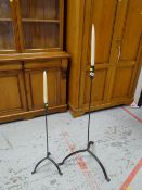 Two wrought iron standing candle sconces together with candles