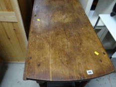 An antique circular drop leaf walnut dining table with barley-twist legs