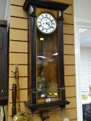 An ebonized Vienna-style wall clock