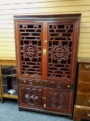 An Oriental hardwood Chinese-style cabinet with open carved doors above a two-drawer two cupboard