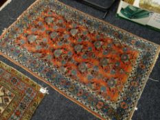 A vintage Middle Eastern wool rug, red ground centre square with a blue decorated border, 86 x