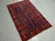 A blue & rust coloured old Baluchi Indian rug, 130 x 84cms