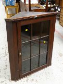 An antique oak and glazed hanging corner cupboard