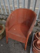 An orange Lloyd Loom-style wicker chair