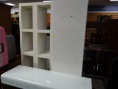 A pair of tall narrow shelving units, a tall narrow cupboard with a three-drawer base together