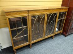 A nice Sheraton-style breakfront astragal glazed bookcase with decorative frieze & on raised feet,