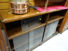 A vintage dark oak double bookcase with sliding glass doors