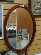 A vintage oval mahogany frame bevel glass wall mirror