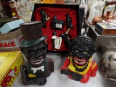 Two metal black boy novelty money boxes together with a boxed set of six jazz band figures