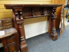 An early twentieth century carved mahogany fire surround with column supports & upper shelf, 138 x