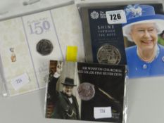 A Royal Mint 65 years Shine Through the Ages £5 coin together with a Royal Mint Beatrix Potter