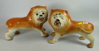 A pair of Staffordshire standing lions with glass eyes