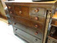 An early twentieth century oak chest of drawers with barley twist decoration to the sides, five