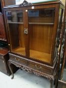 A reproduction mahogany glazed two-door display cabinet with two-drawers & on raised feet, 159 x