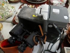 A cased pair of binoculars & a vintage Canon cine camera