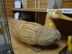 A straw & carved wood duck