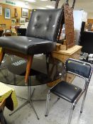 A circular black glass & chrome top dining table with four chrome cushion chairs together with a