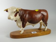 Ceramic figure of a bull on wooden plinth