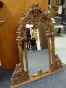 A profusely carved pine three-section overmantel mirror