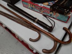 Three vintage walking canes together with an American prison riot baton