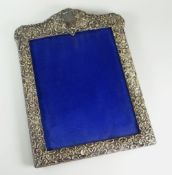 SILVER PORTRAIT FRAME of high-Victorian style relief decoration and with engraved cartouche,