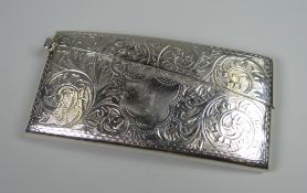 A GEORGE V FOLIATE ENGRAVED SILVER CARD CASE of curved form and with hinging lid, Birmingham 1911,