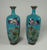 A PAIR OF ANTIQUE CLOISONNE MINIATURE VASES in teal-green with wildflowers and grasses in enamel,