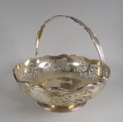 A PIERCED SILVER SWING HANDLE FOOTED BASKET by Joseph Rogers, Sheffield 1927, 24.4ozs