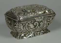 A VICTORIAN IMPORT SILVER CASKET of sarcophagus form and having a hinged lid with raised foliate