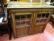 Two door bookcase cupboard with six sectional glazed twin doors with carved detail