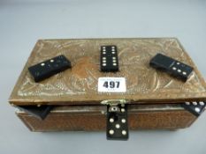 Copper repousse decorated box containing a quantity of plastic dominoes