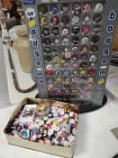A display stand for metal novelty badges together with a tin containing many hundreds of various pop